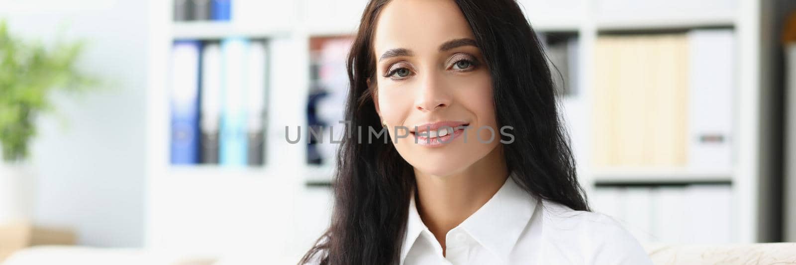 Portrait of young woman reading book sitting on sofa at home, interesting story. Lady involved in process, development. Hobby, leisure, chill day concept