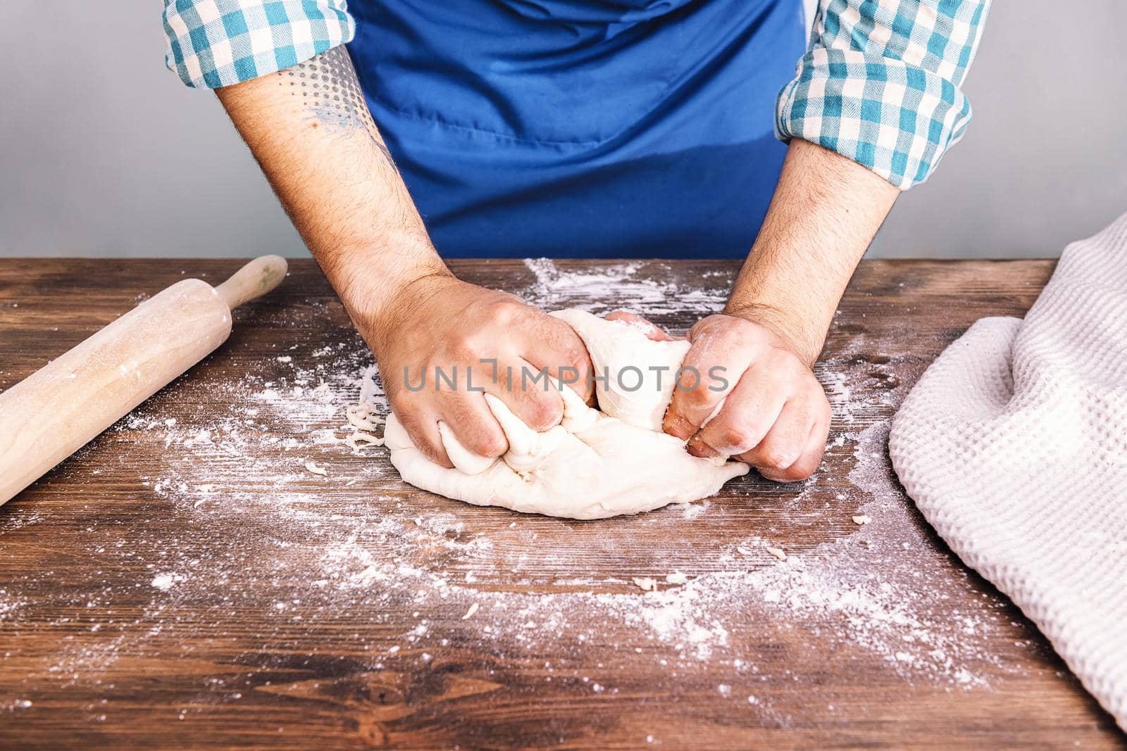 hands of an unrecognizable man kneading homemade bread dough, concept of healthy food at home