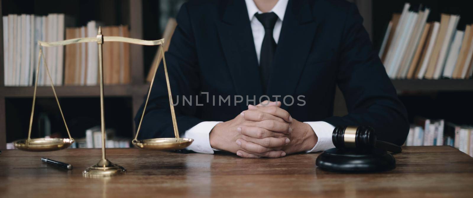 Business and lawyers discussing contract papers with brass scale on desk in office. Law, legal services, advice, justice and law concept by wichayada