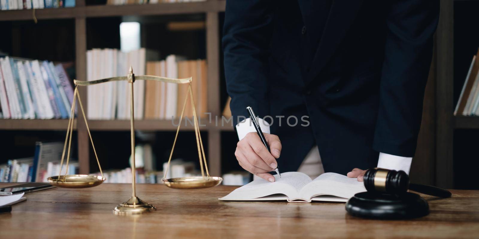 justice and law concept.Male judge in a courtroom on wooden table and Counselor or Male lawyer working in office. Legal law, advice and justice concept..