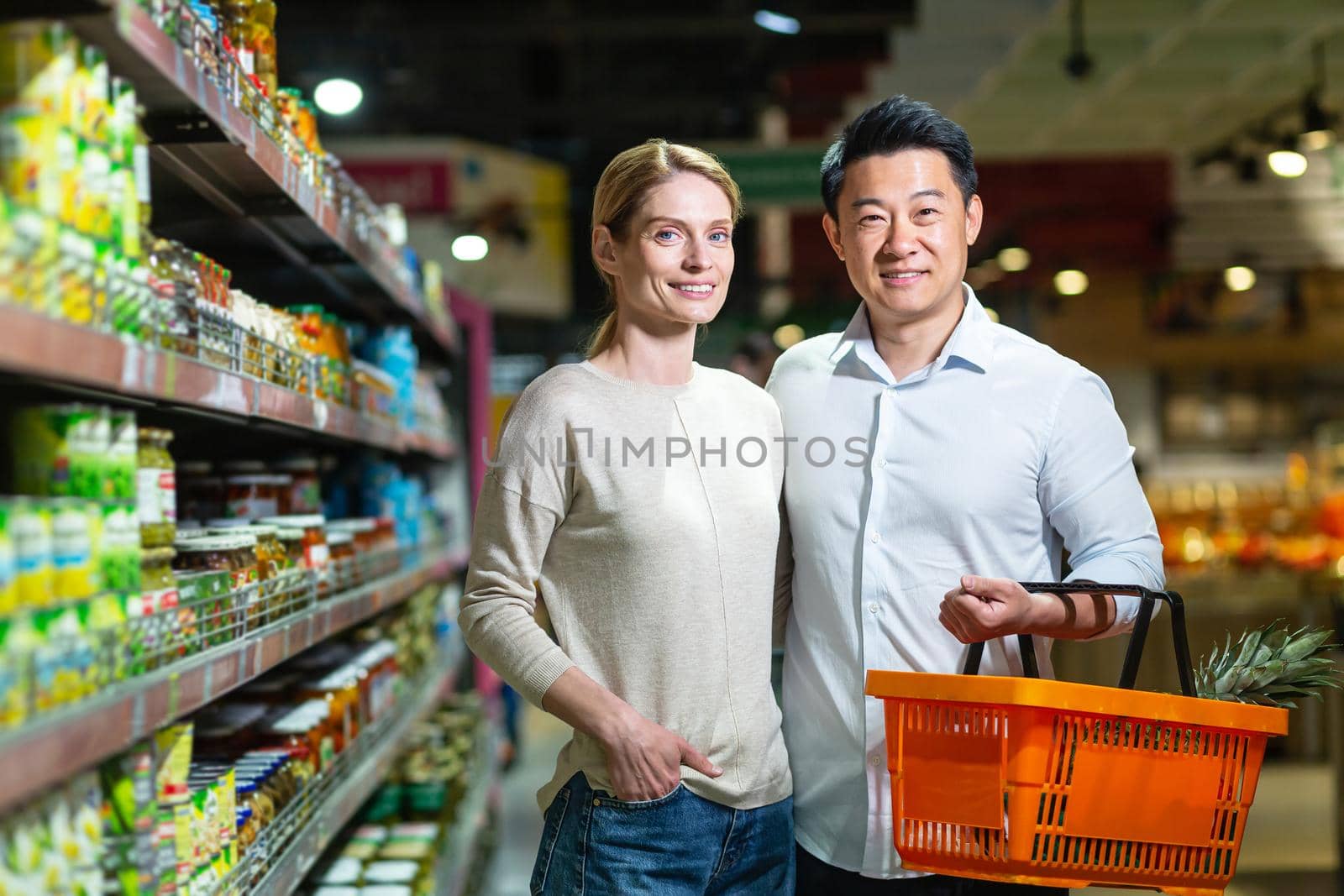 Happy married couple Asian man and woman looking at camera and smiling by voronaman