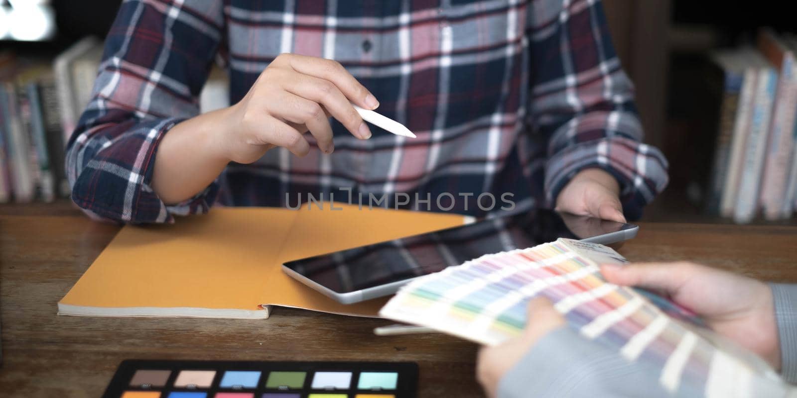 Two artists working on tablet, colour paper tone on workspace at the office by wichayada