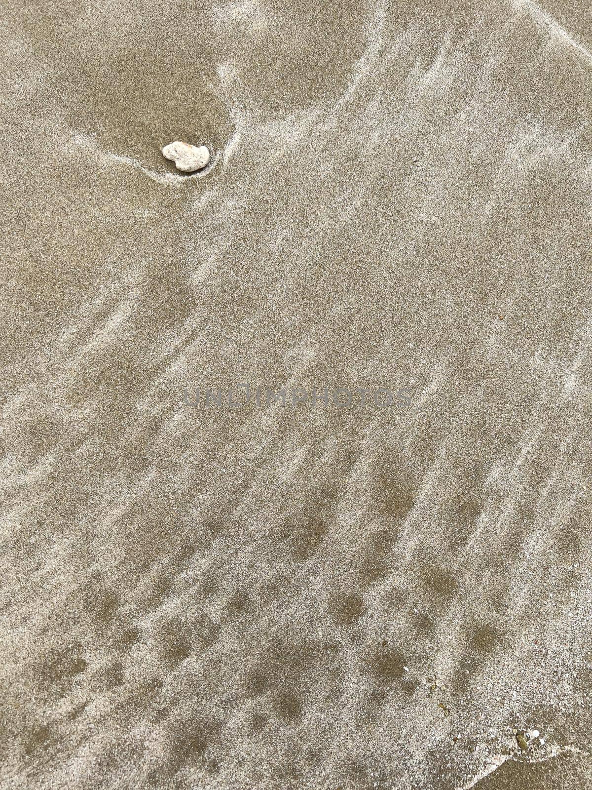 Small wave of water on clear sandy beach