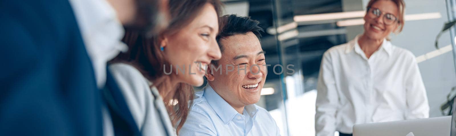 Close up of smiling confident businesswoman on business meeting with colleagues in office by Yaroslav_astakhov