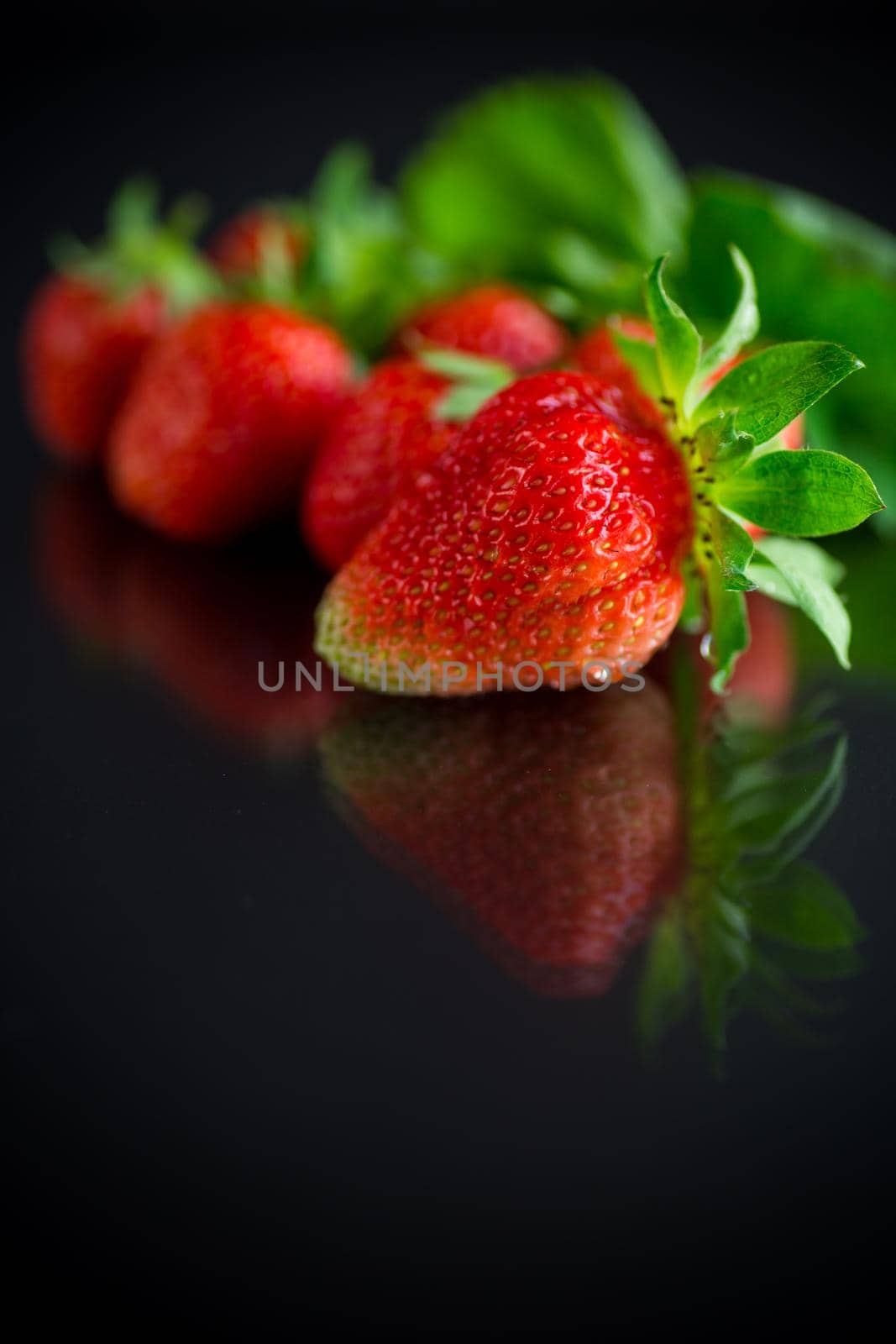 Ripe juicy red strawberry isolated on black background
