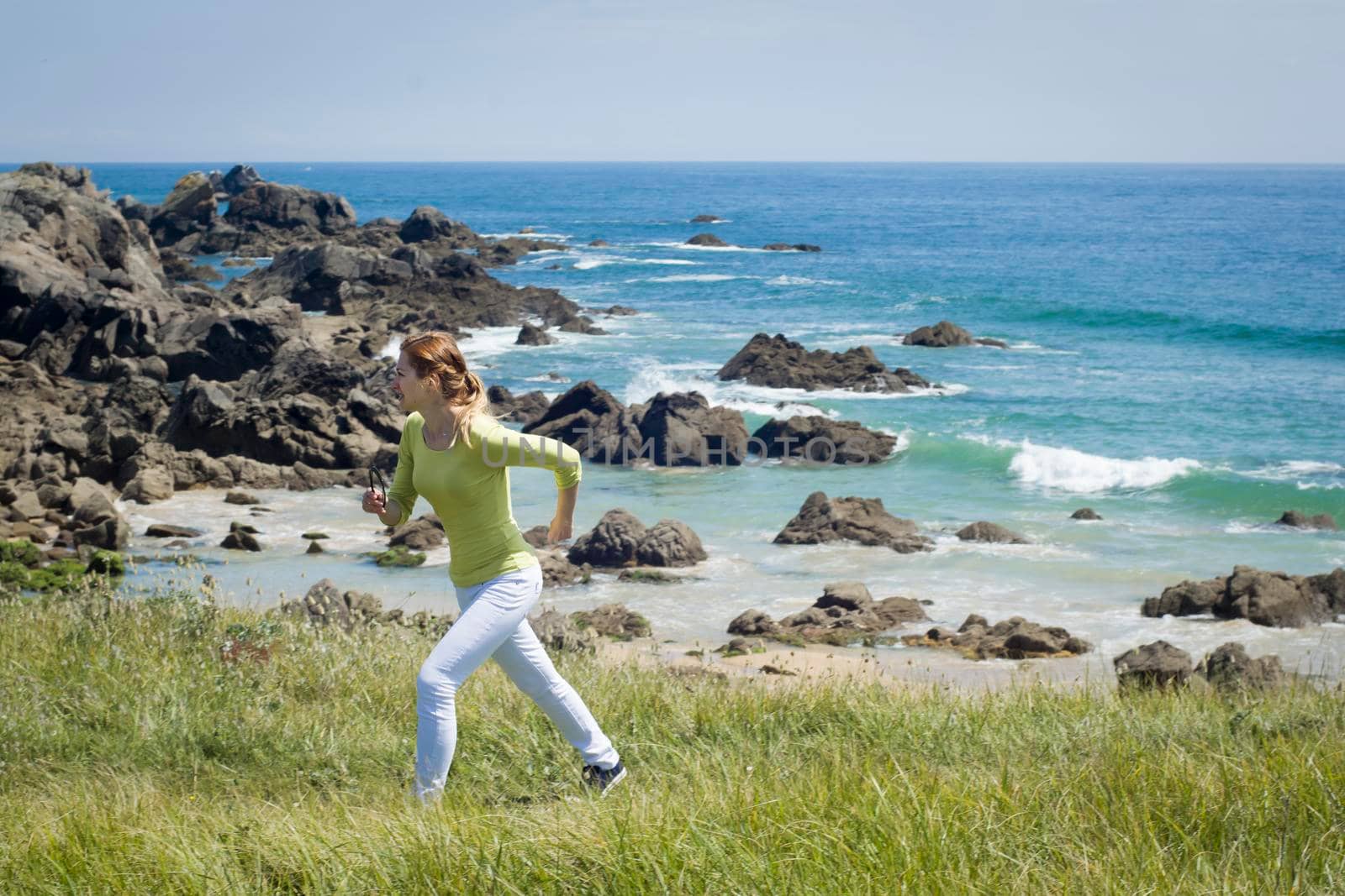 Young woman running on a seaside at sunday