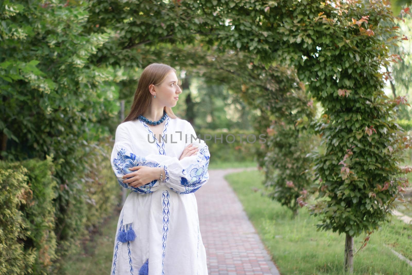 Portrait of young woman wearing blue national traditional embroidered shirt. pretty girl outdoor dressed in patriotic clothes.