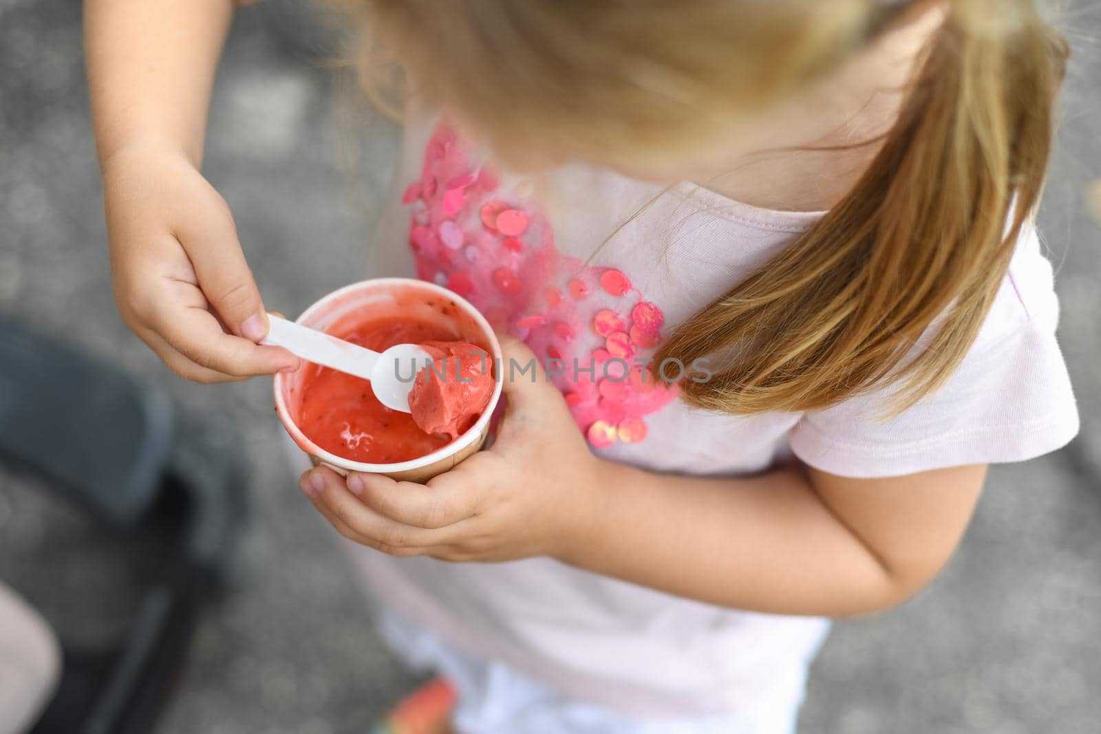 Girl eats pink ice cream