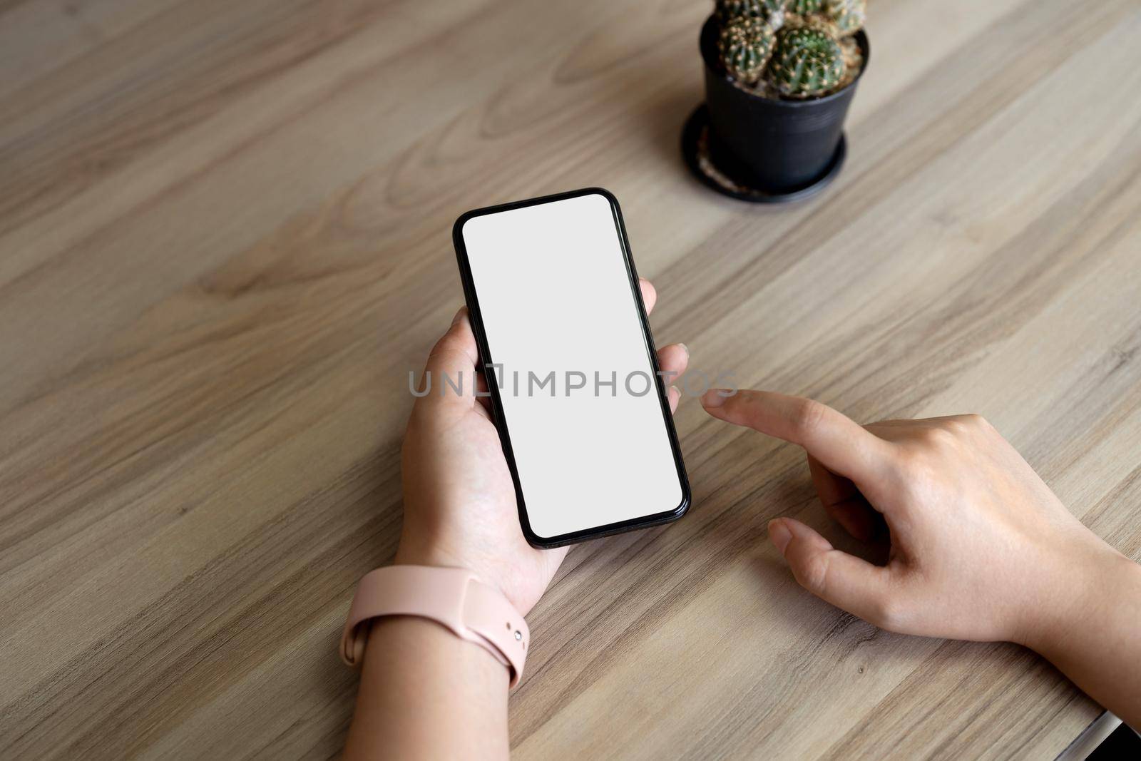 Top view Woman sitting and holding blank screen mock up mobile phone.