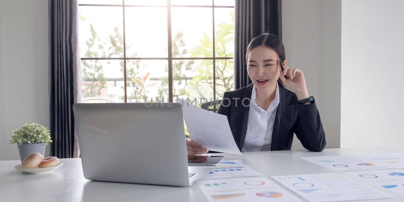 Portrait of an Asian woman working on a tablet computer in a modern office. Make an account analysis report. real estate investment information financial and tax system concepts.