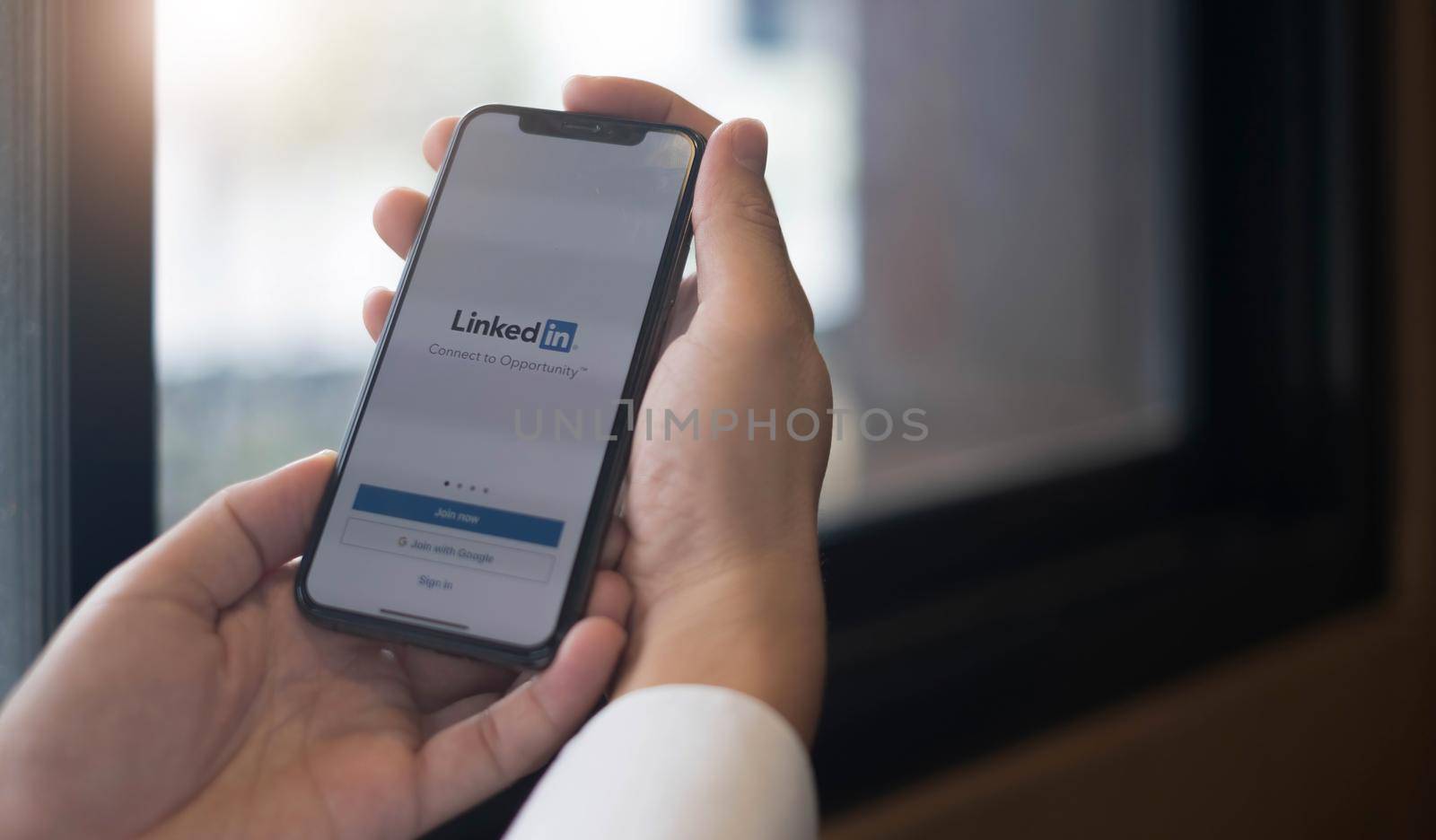 CHIANG MAI, THAILAND, JUL 13, 2022 : A women holds Apple iPhone Xs with LinkedIn application on the screen.LinkedIn is a photo-sharing app for smartphones. by wichayada