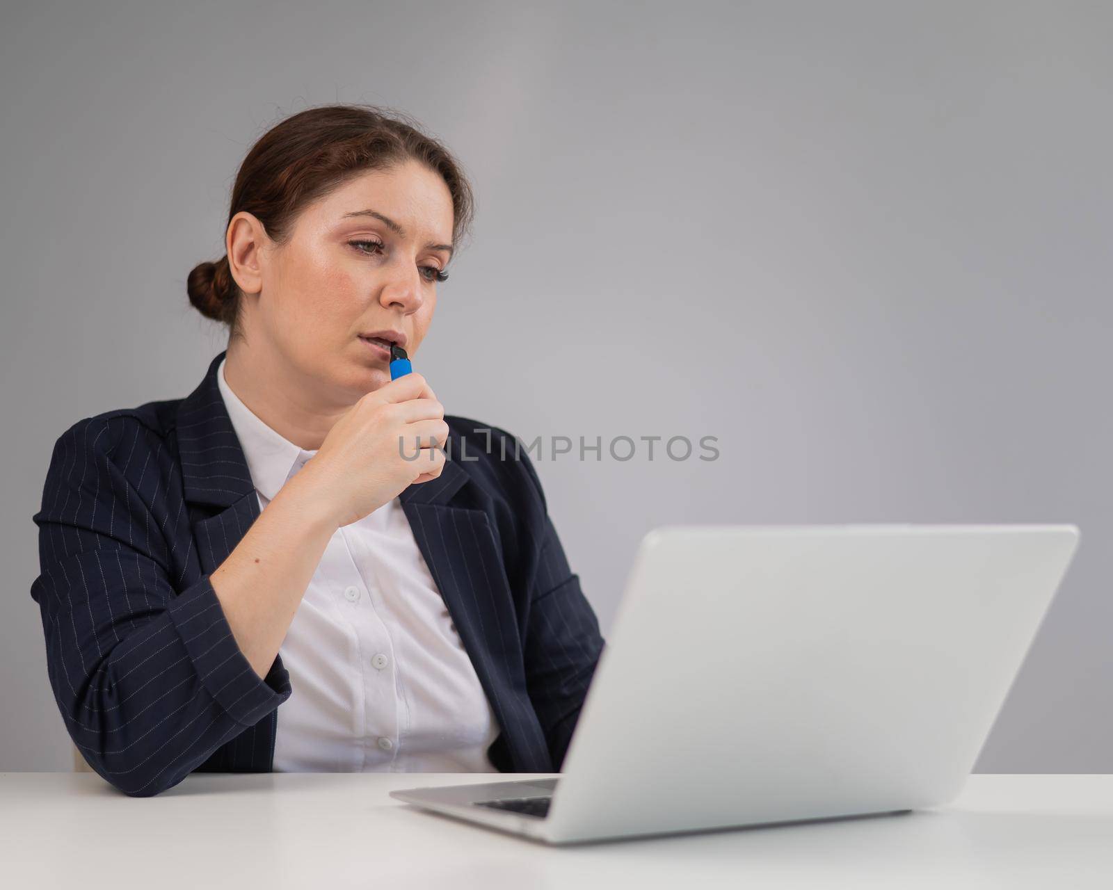 Business woman smoking a disposable vape while sitting at her desk. by mrwed54