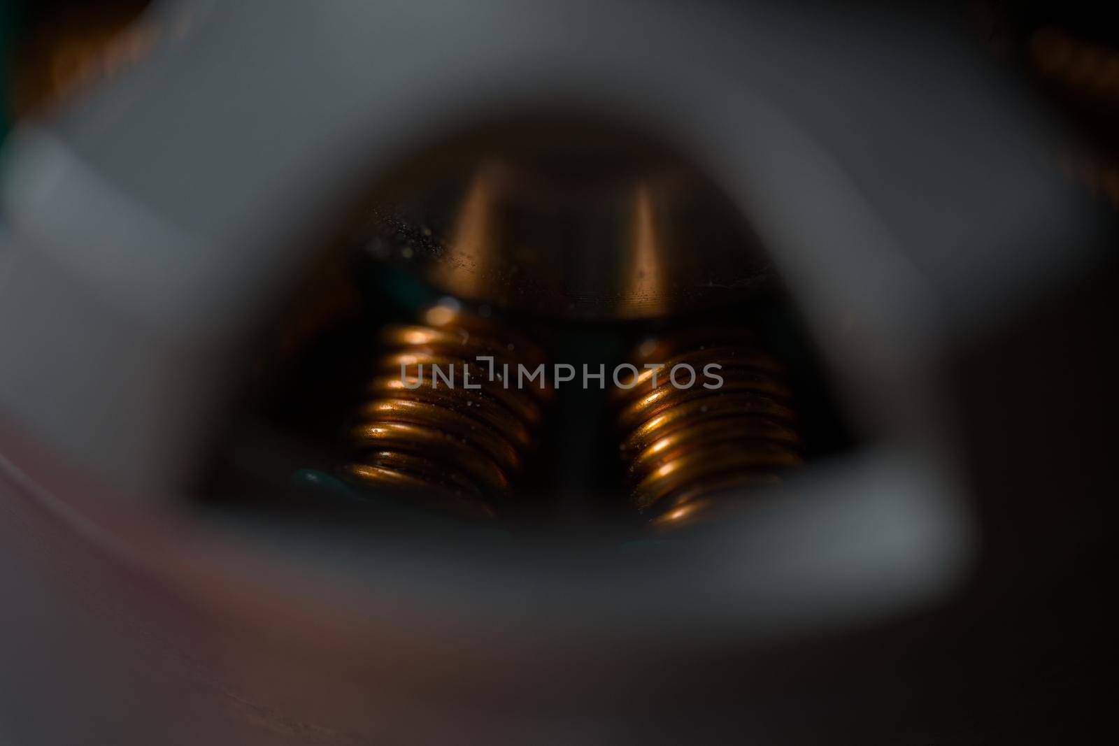 Dark close up of shiny copper coils within a brushless drone motor. Copy space and selective focus with cinematic color style. Super macro scale.