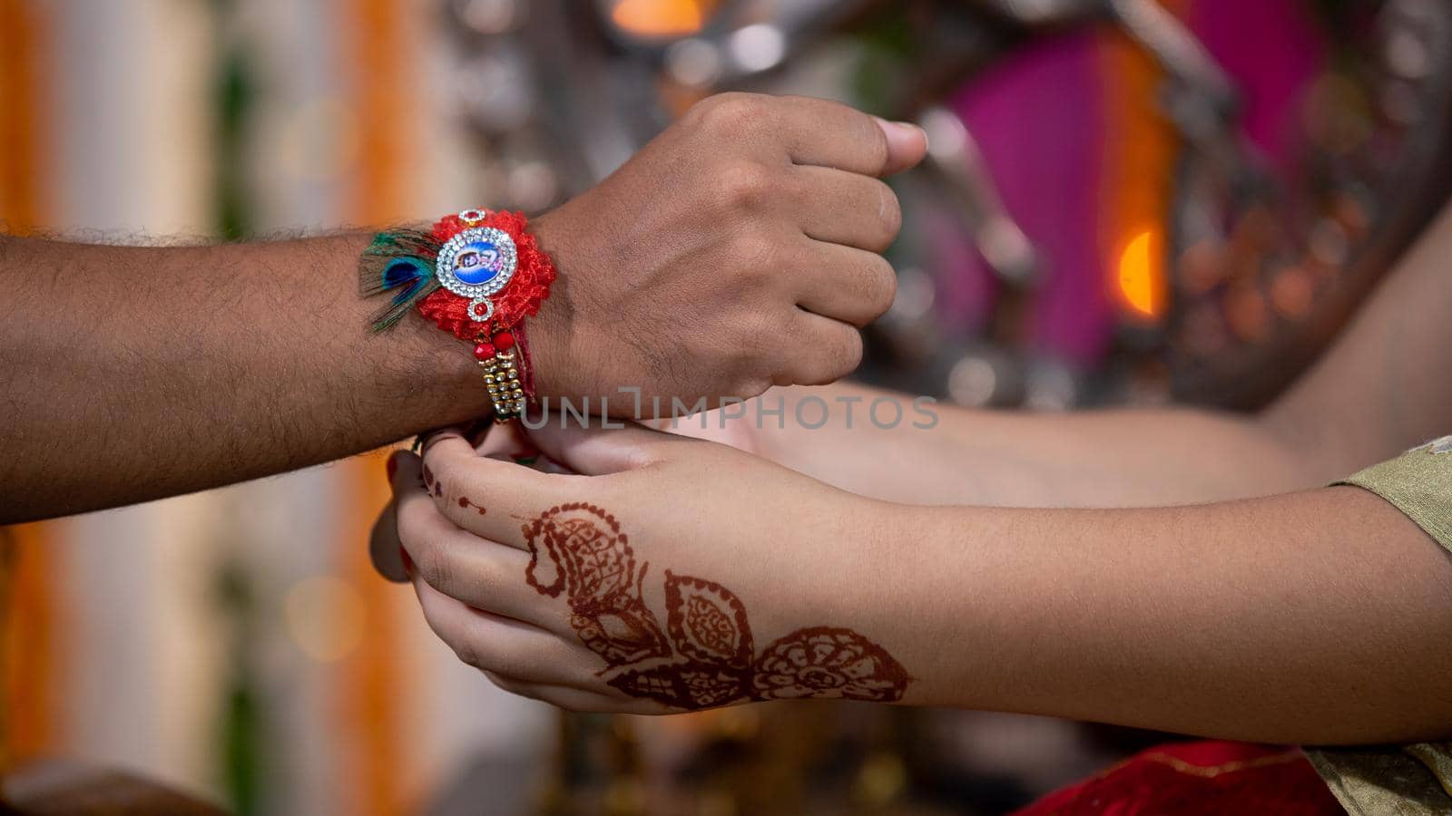 Sister tying the rakhi, Raksha Bandhan to brother's wrist during festival or ceremony - Raksha Bandhan celebrated across India as selfless love or relationship between brother and sister