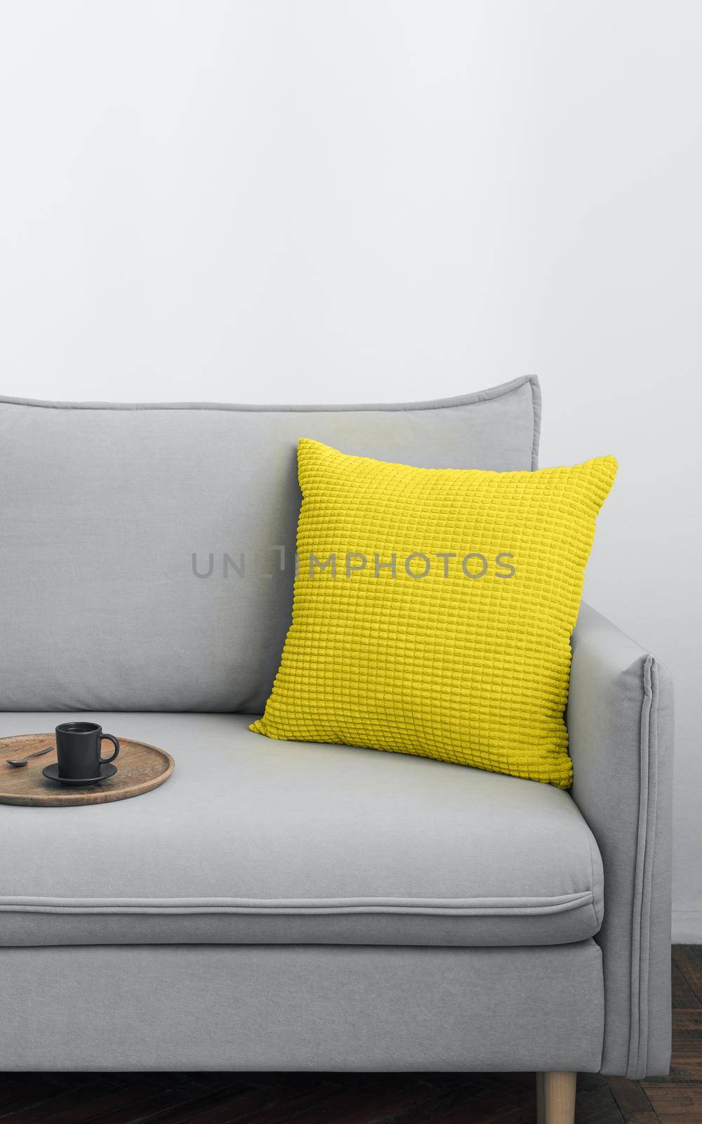 Illuminating yellow and ultimate Gray - trendy colors of year 2021 in interior. Gray sofa with yellow pillow in modern scandinavian style room interior. Vertical crop for social media, copy space