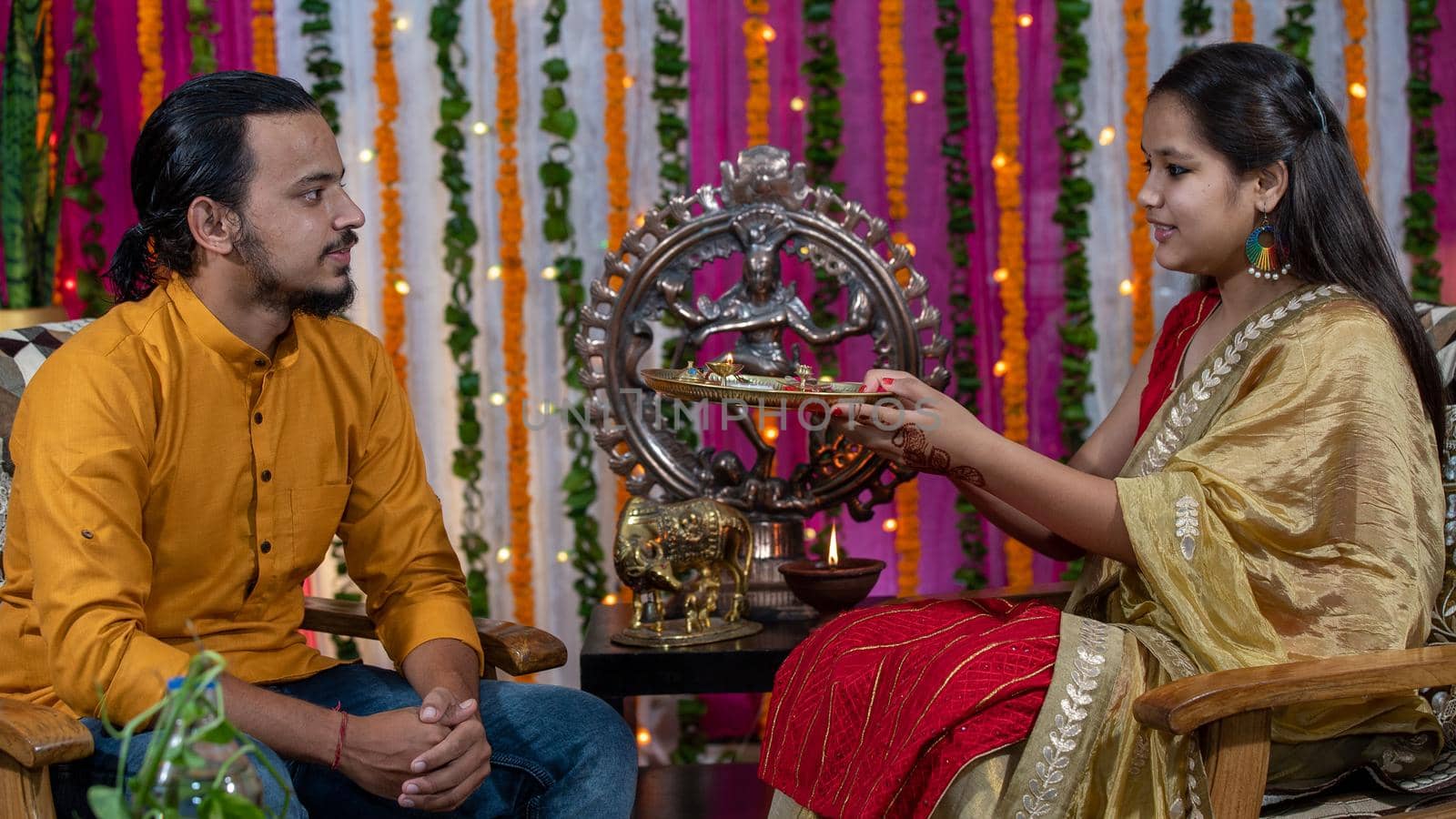 Indian families celebrating Raksha Bandhan festival a festival to celebrate the bond between brother and sister. Rakhi celebration in India. Feeding sweets, applying tikka.