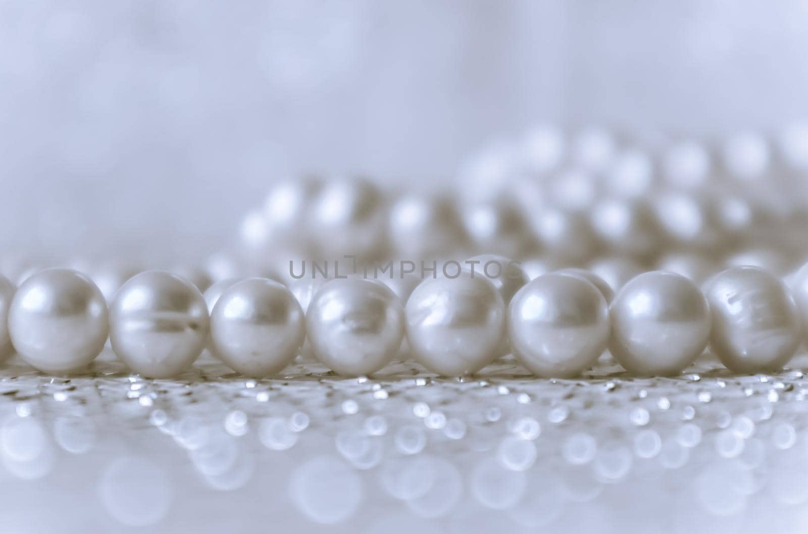 Nature white pearl beads on sparkling background by Olayola