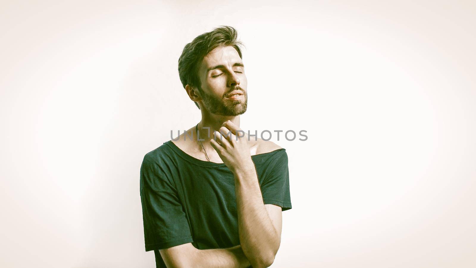 Handsome Man Relaxes Set His Face To The Light, Caucasian Young Man Closed His Eyes Posing In Studio On A White Background, Concept Of Male Beauty