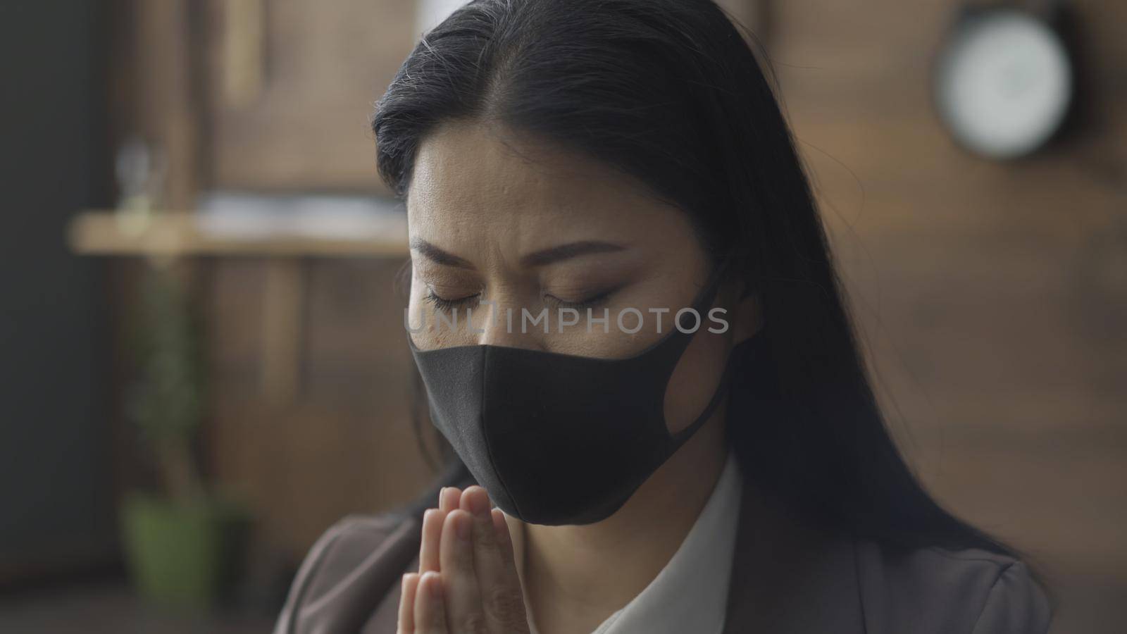 Beautiful Woman In Protective Mask Portrait Of Asian Woman Praying In Office Closing Her Eyes, Business Woman Isolated During Epidemic Of Coronavirus, Close Up Shot