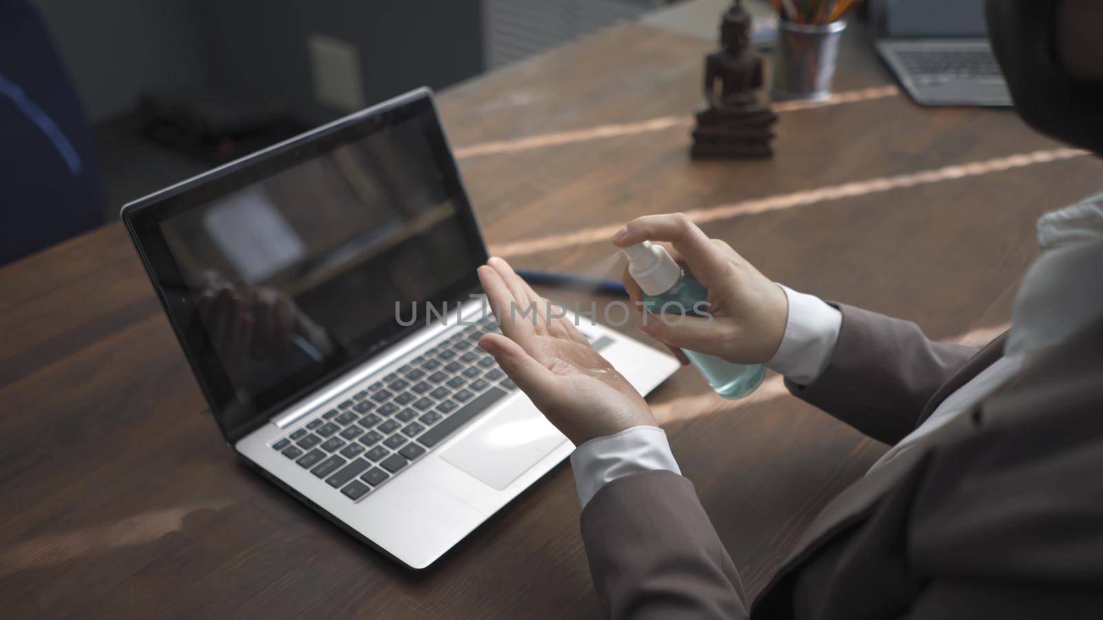 Business Woman's Hands Holding Sanitizer, Woman In Formalwear Using Hand Sanitizer Sprays While Working With Laptop At Table, Side View