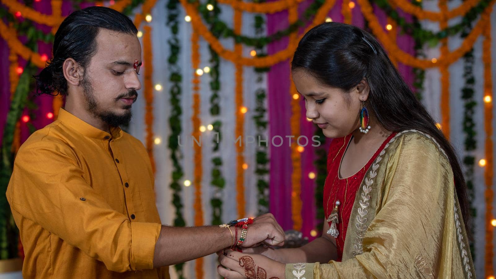 Sister tying the rakhi, Raksha Bandhan to brother's wrist during festival. by stocksvids