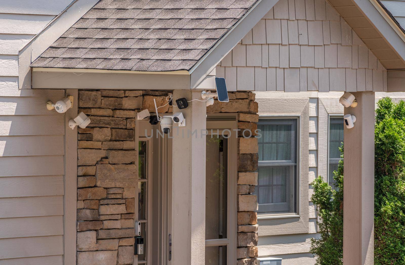 Modern entrance door of home surrounded by security video cameras and sensors for protection against burglary