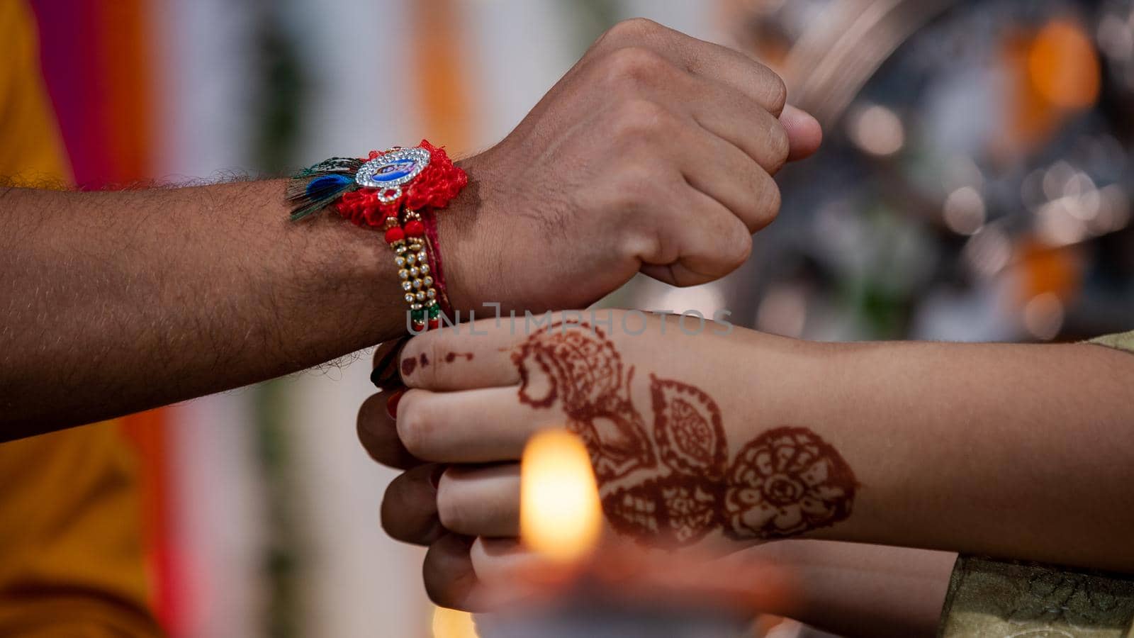 Sister tying the rakhi, Raksha Bandhan to brother's wrist during festival. by stocksvids