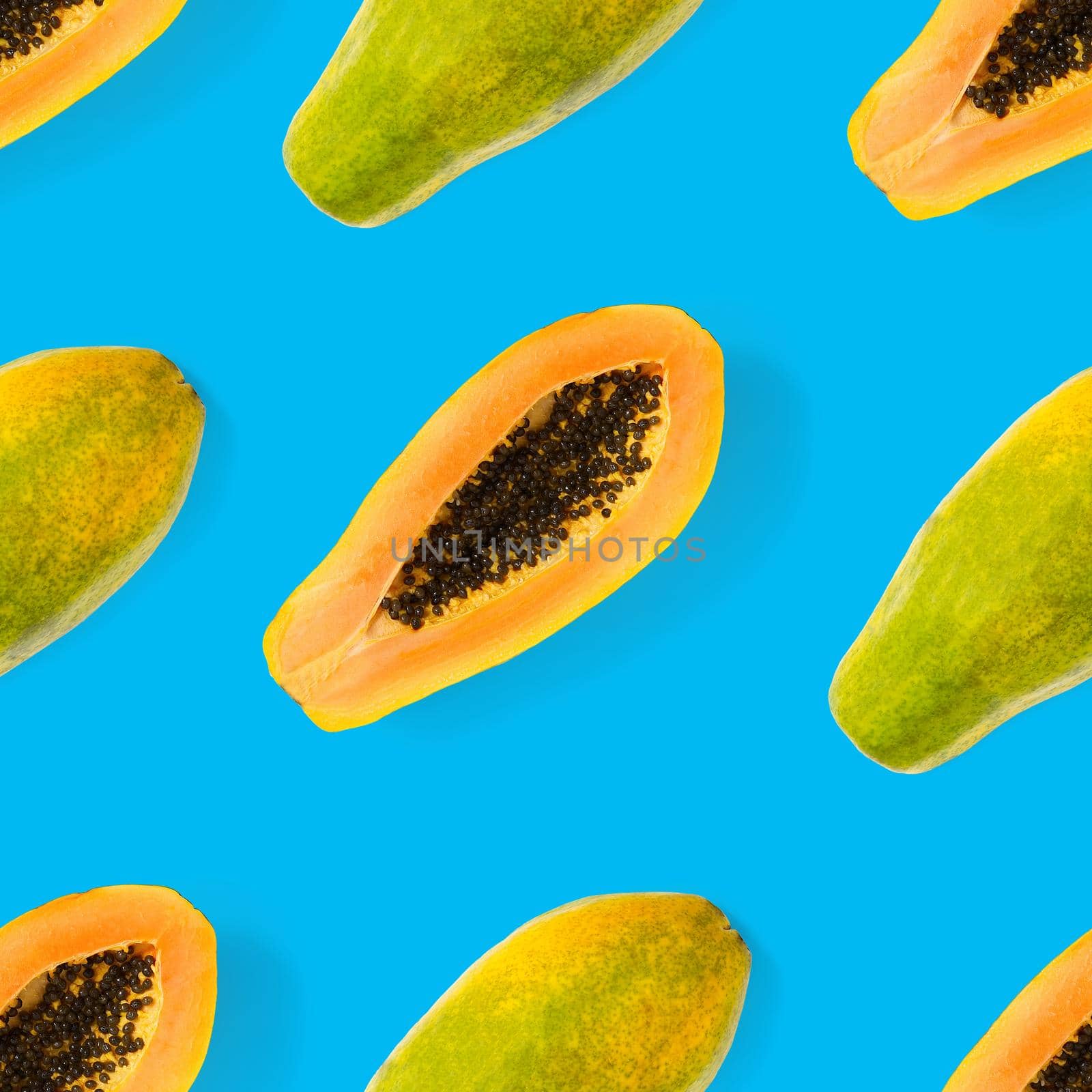 Fresh ripe papaya seamless pattern on blue background. Tropical abstract background. Top view. by PhotoTime