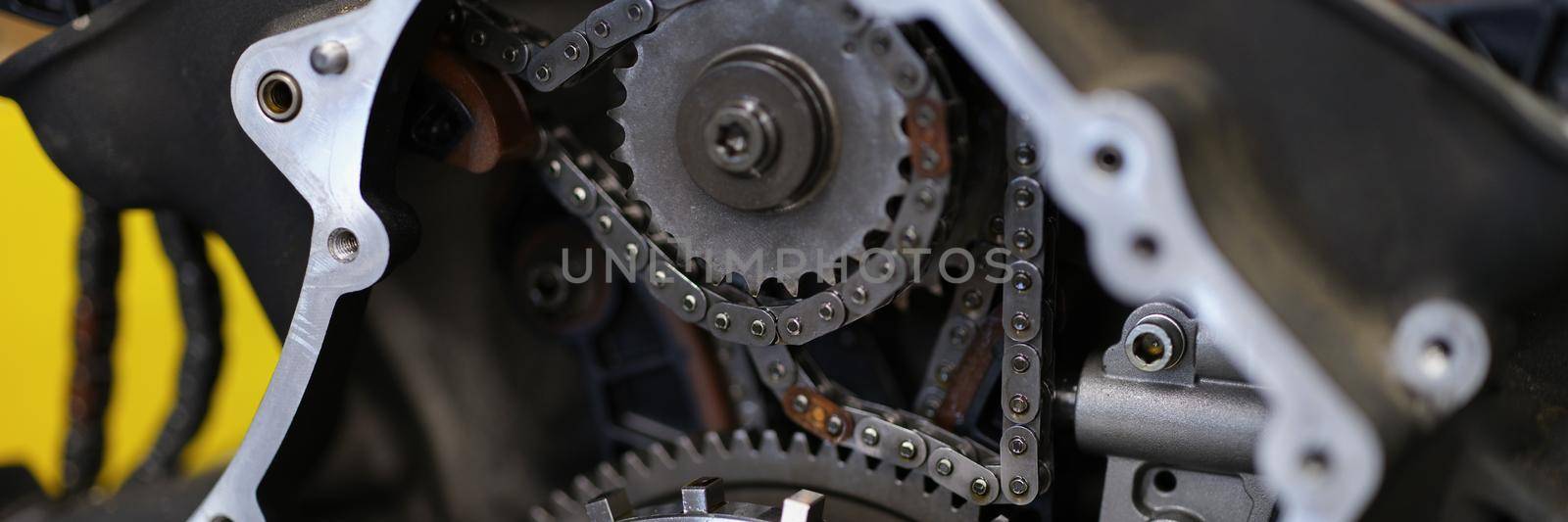 Close-up of motorbike construction system with metal chain and others details. Brand new bike or just after maintenance in service centre. Vehicle concept