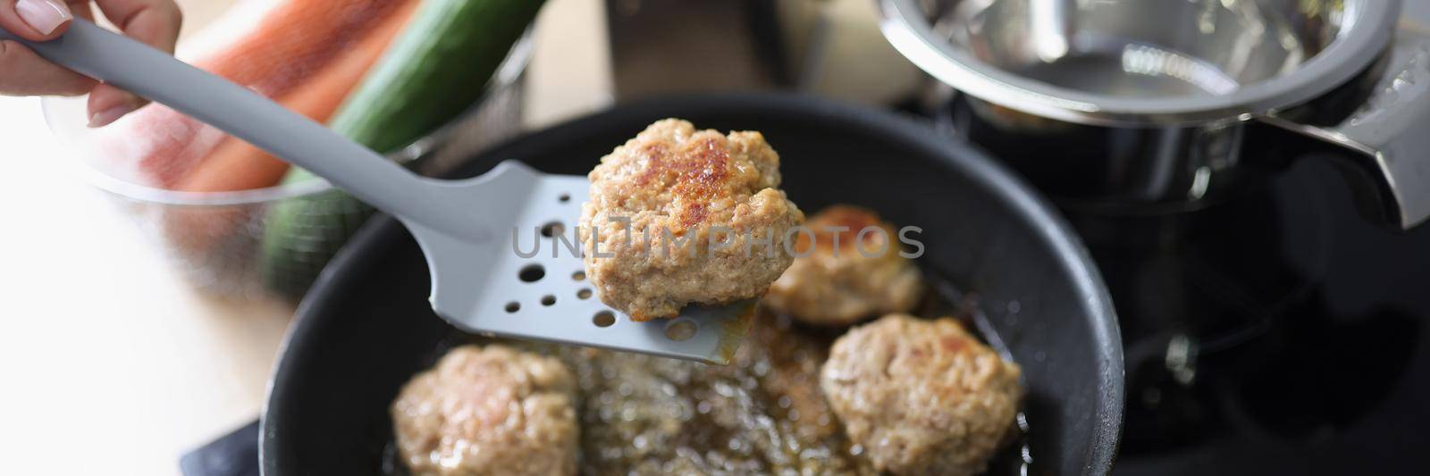 Close-up of tasty aromatic meat balls frying in oil on pan on kitchen stove. Housewife cooking yum meal using tool. Chef, food, eating, nutritious concept