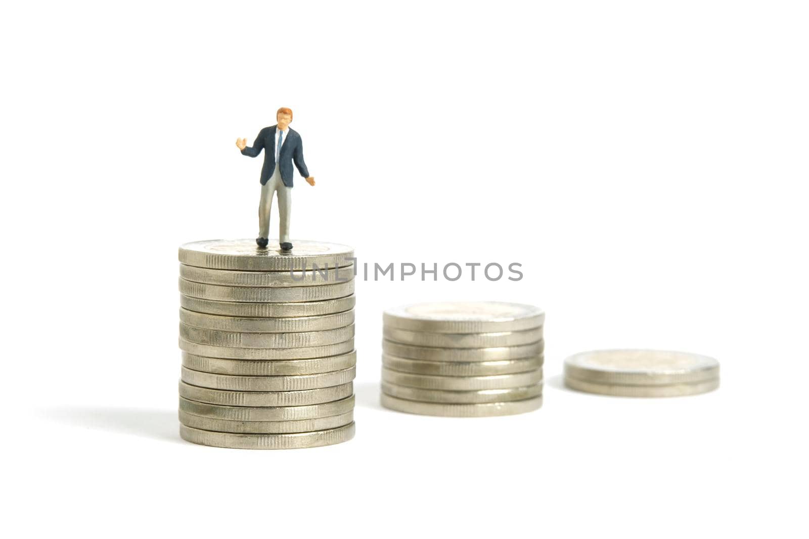 Miniature people toy figure photography. Financial plan concept. A shrugging businessman stand above decreasing coin money stack. Isolated on white background. Image photo