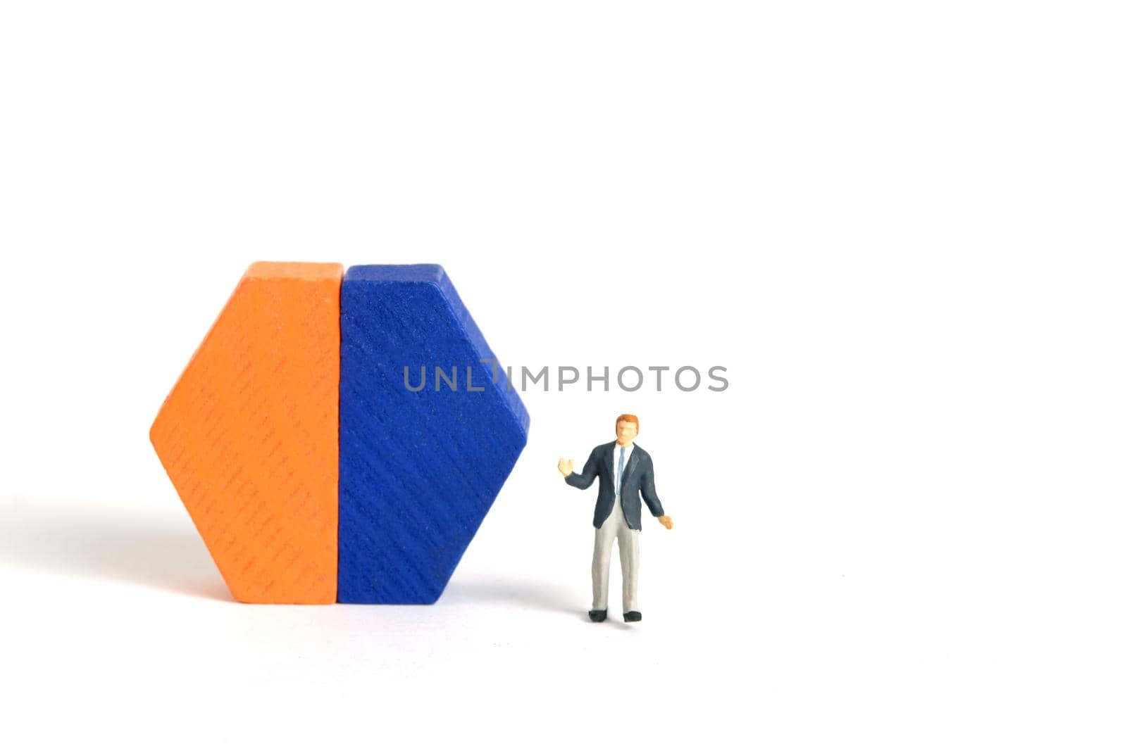 Miniature people toy figure photography. A shrugging businessman doing business presentation standing in front of wooden chart diagram. Isolated on white background. Image photo by Macrostud