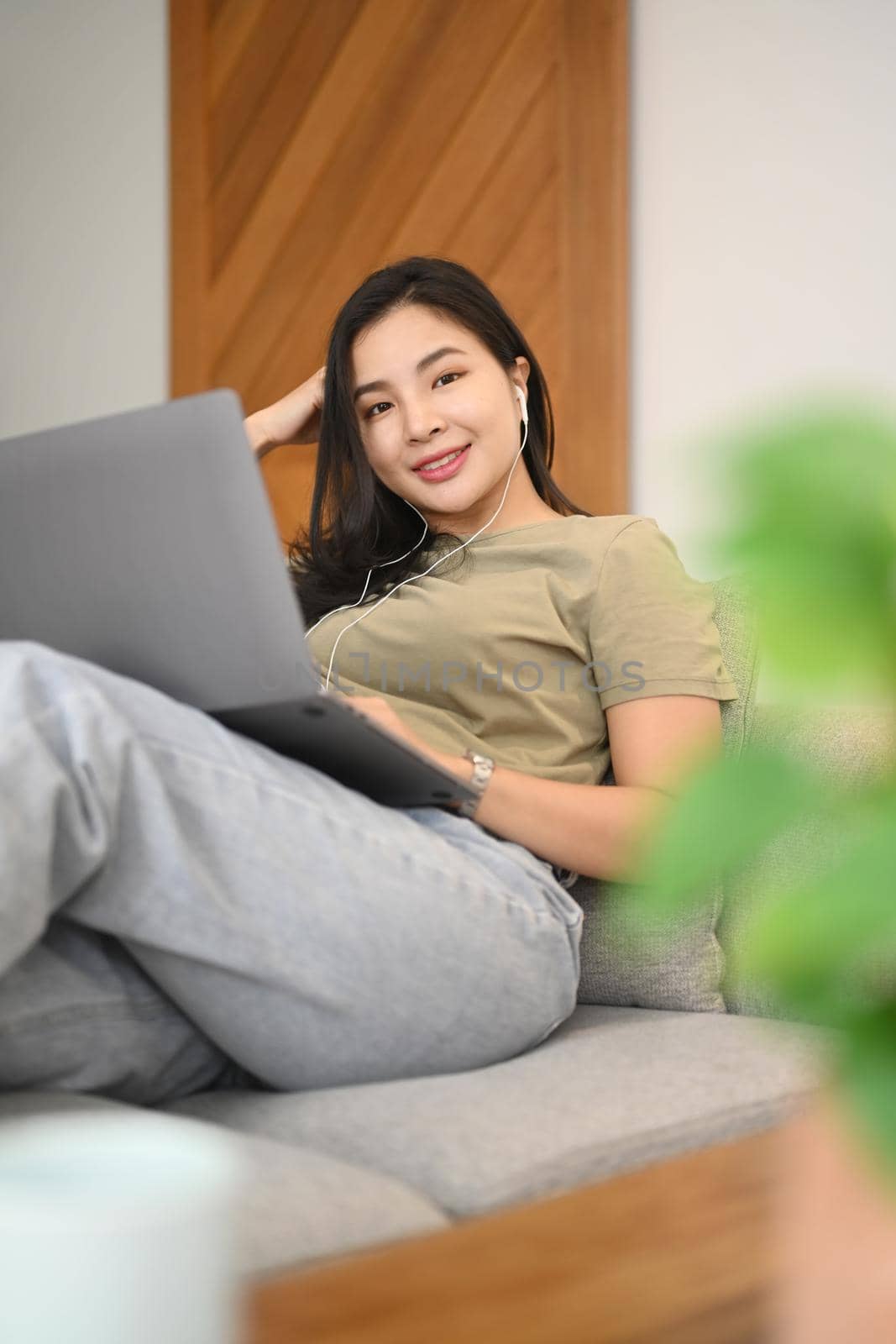 Young woman browsing internet, chatting with friends on laptop at home.