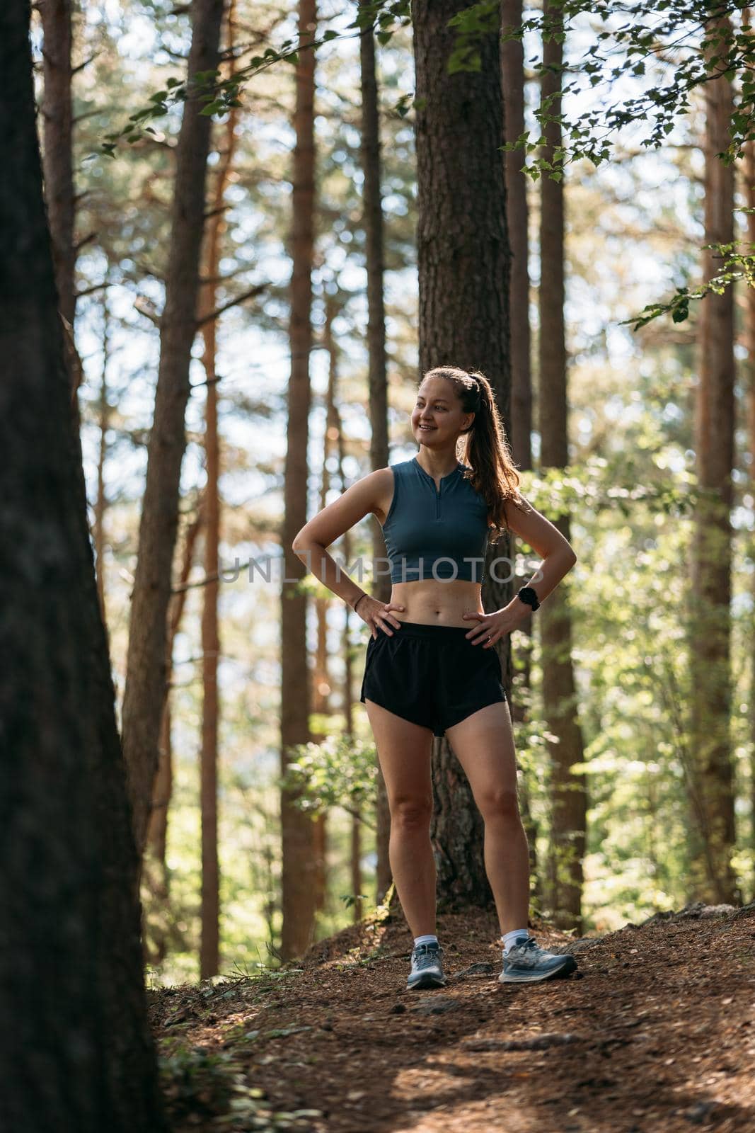 Happy girl practice trial running in the morning forest. Concept of sports and fitness relaxation in nature.