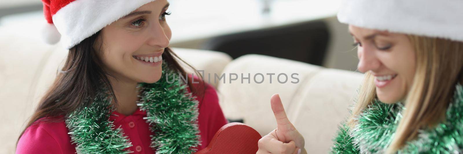 Portrait of woman receive present from sister in red box new model of smartphone. Festive mood and christmas outfit, celebrate new year. Holiday concept