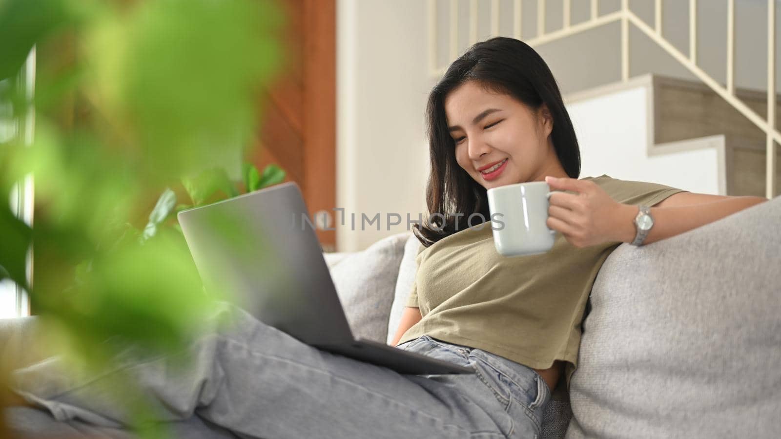 Joyful young woman browsing internet, chatting with friends on laptop computer.