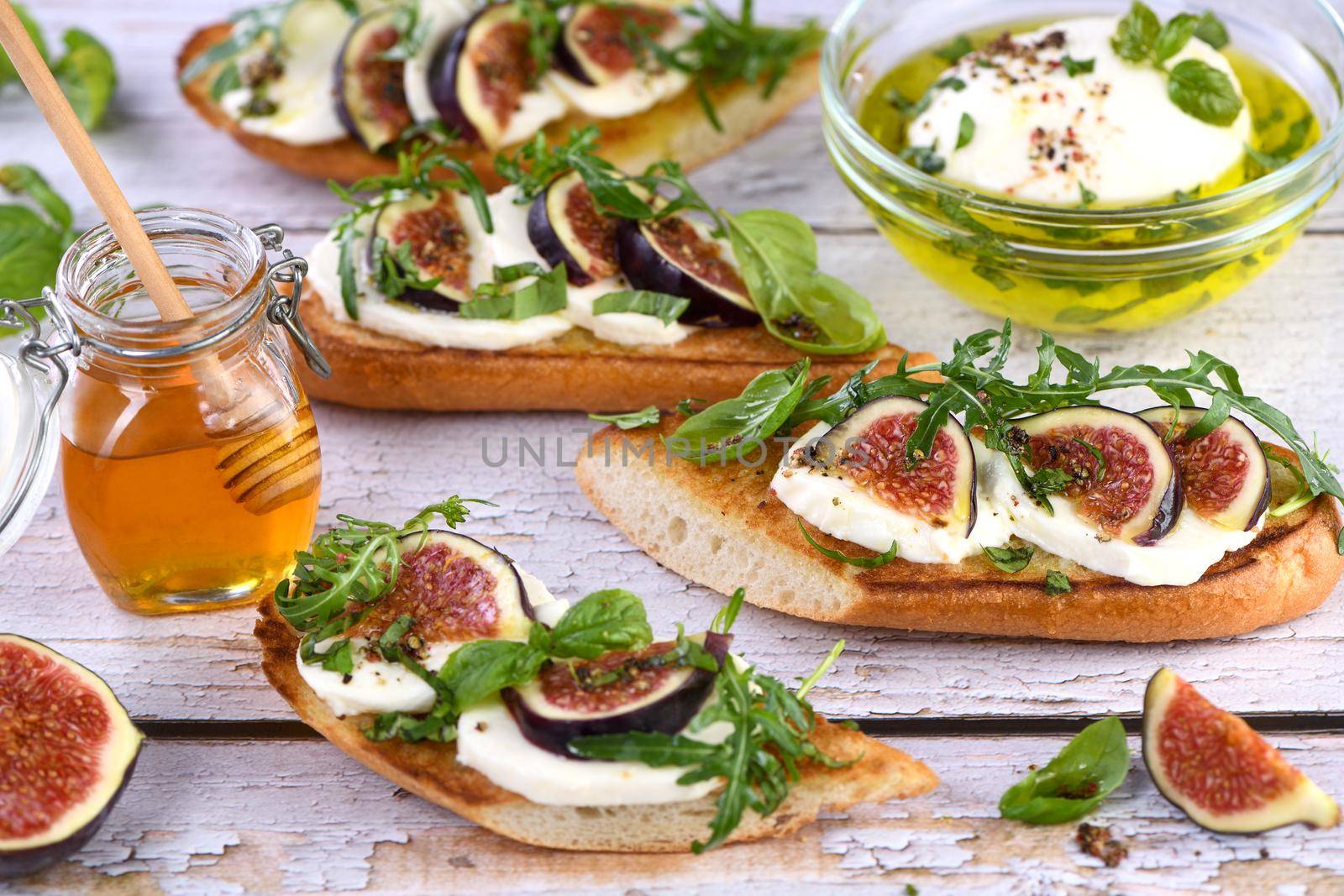 Bruschetta with mozzarella, arugula and figs, seasoned with honey and spices