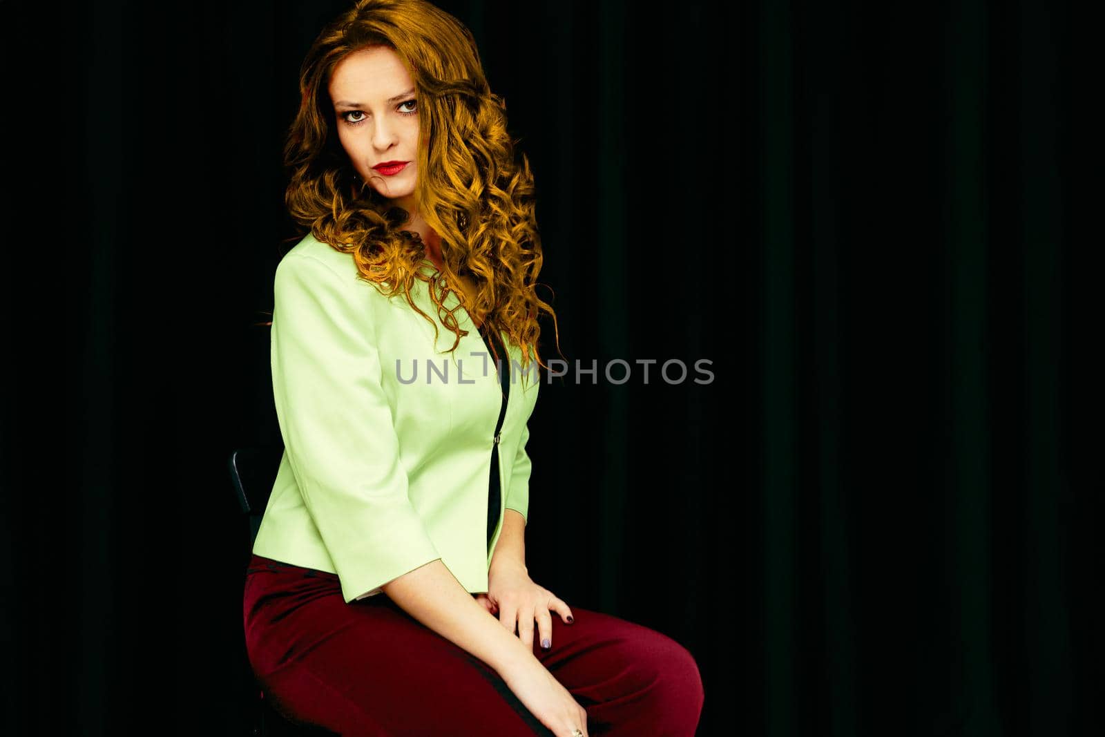 Young pretty redhead woman in red trousers and light green jacket. Businesswoman by jovani68