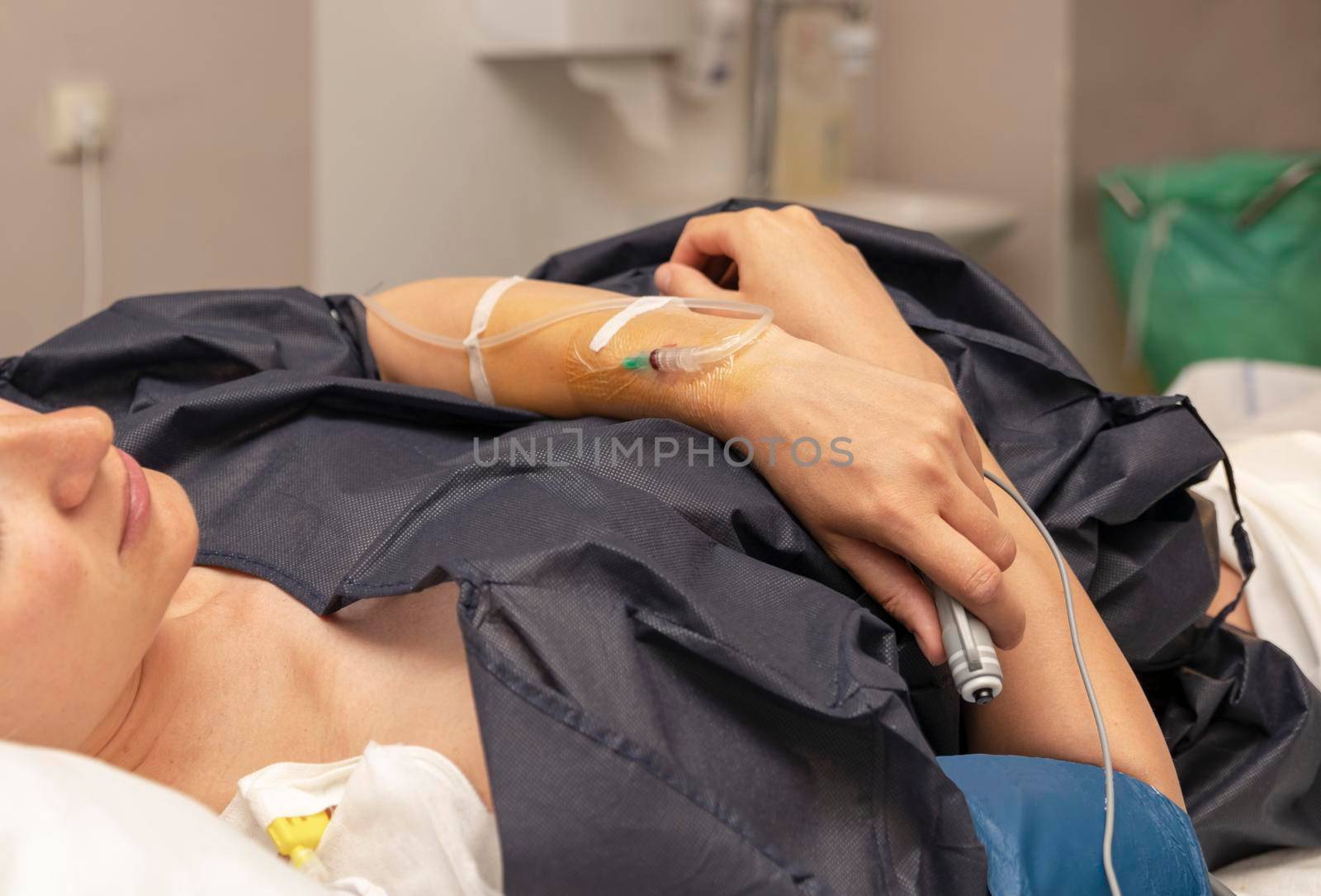 The woman in a delivery room with a dropper and push the remote button for a regular dose of epidural anesthesia