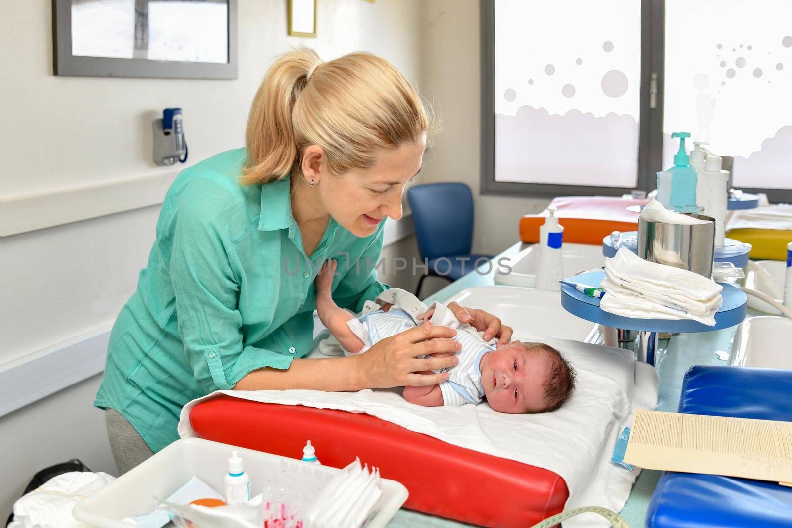 Mother cares for her newborn baby in the maternity hospital. First bath.