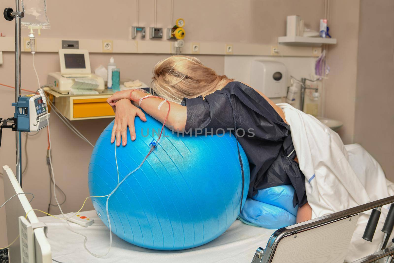 Woman during contractions on a blue fitness ball Parturition hospital