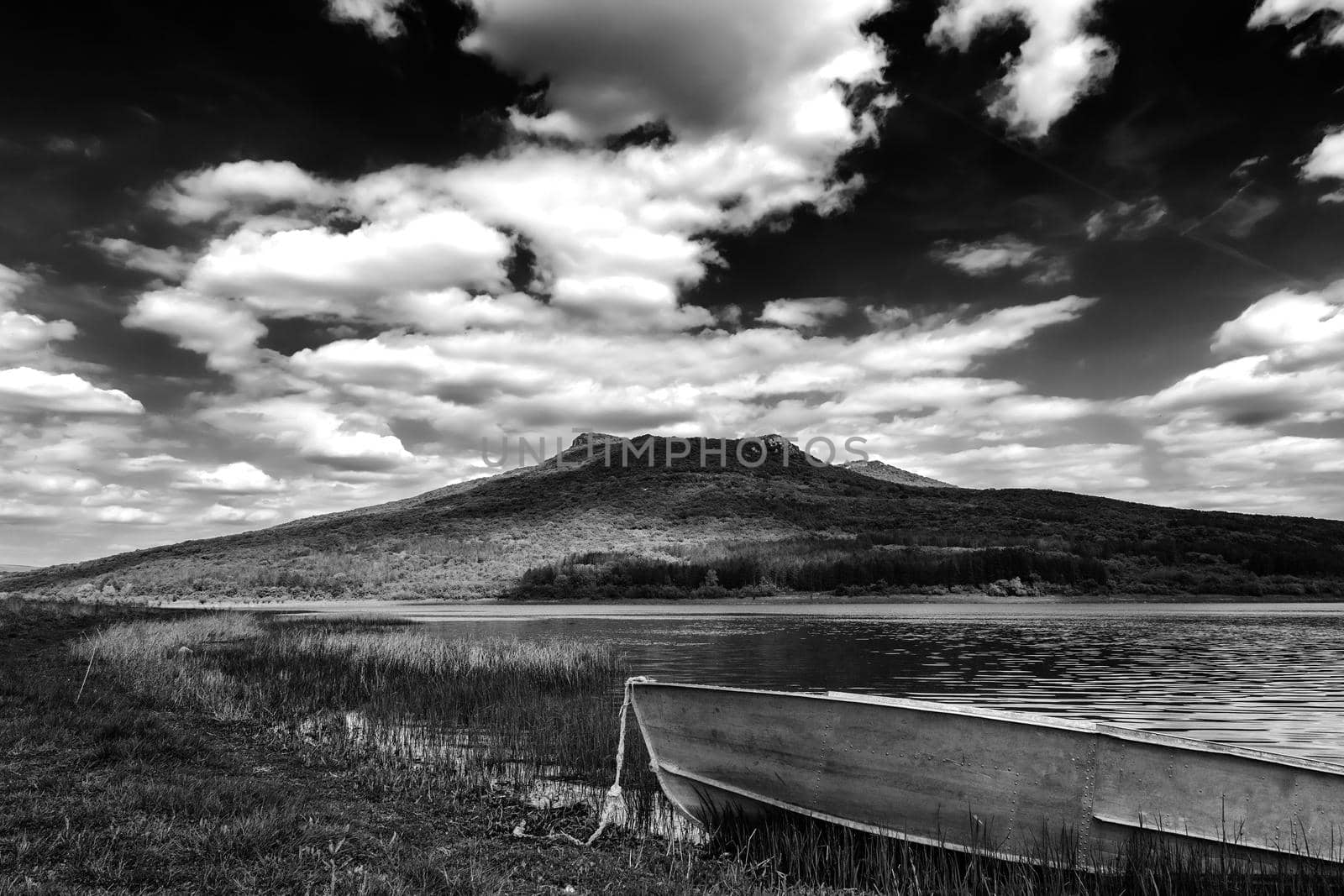 lonely old boat on the lake shore. Black and white view