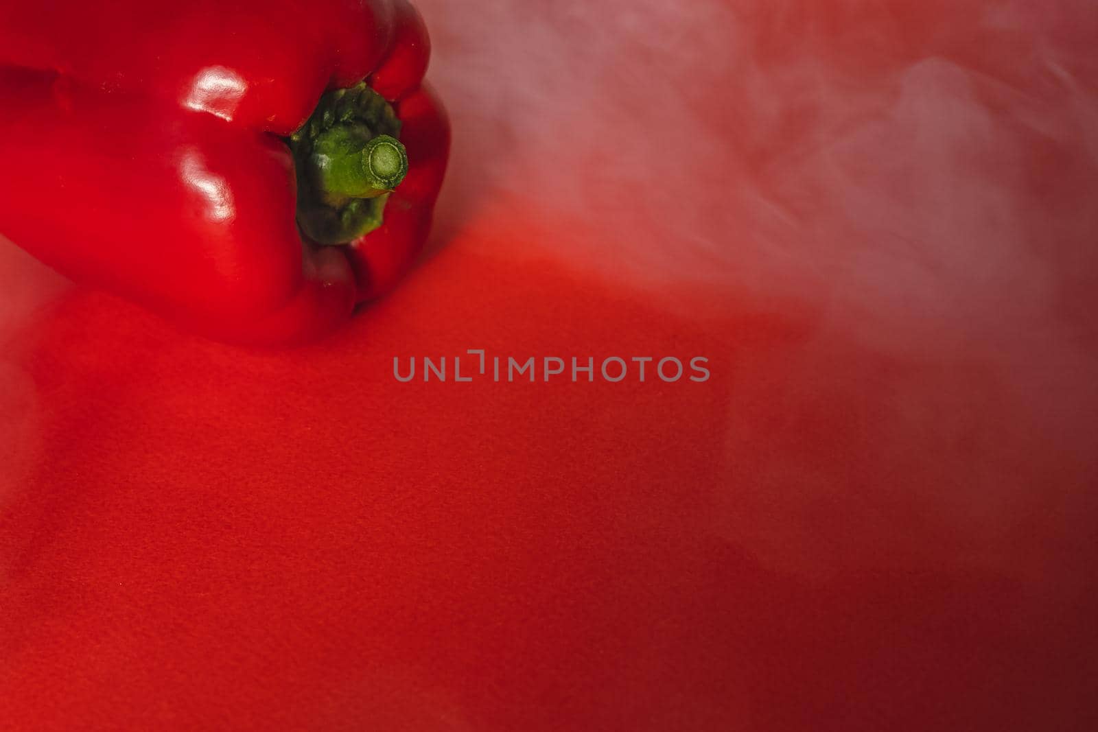 SWEET, fresh RED PEPPER ON RED BACKGROUND With smoke around, pepper. photo for the menu, proper nutrition. fresh vegetables.