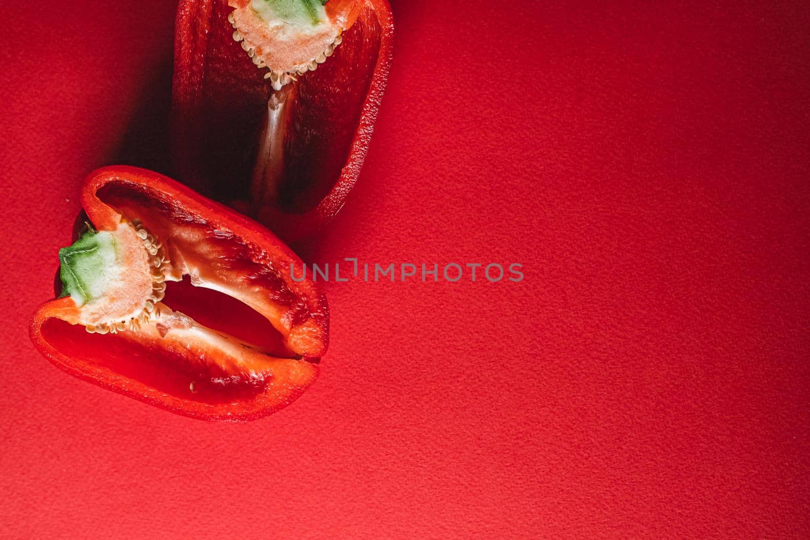 SWEET, fresh RED PEPPER ON A RED BACKGROUND, cut in half. photo for the menu, proper nutrition. fresh vegetables.