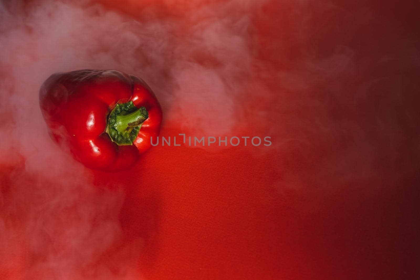 SWEET, fresh RED PEPPER ON RED BACKGROUND With smoke around, pepper. photo for the menu, proper nutrition. fresh vegetables.