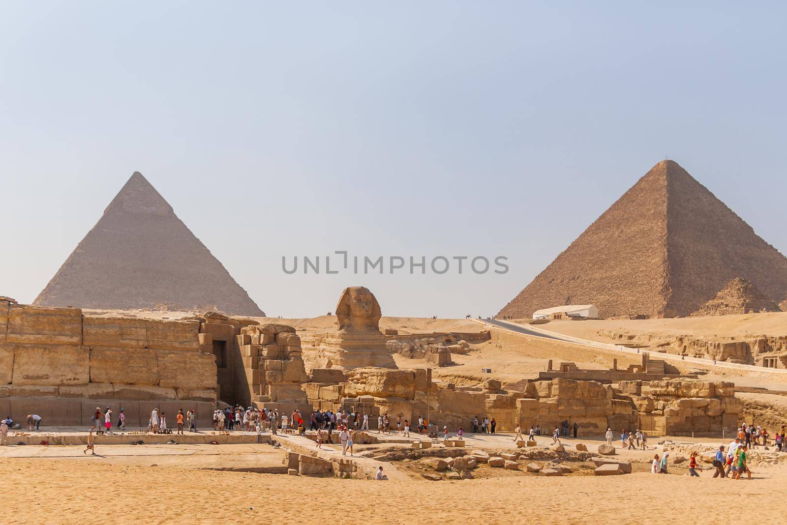 CAIRO, EGYPT - September 11, 2008. Groups of tourists on excursion near Statue of Sphinx and Great Pyramid of Giza. by aksenovko