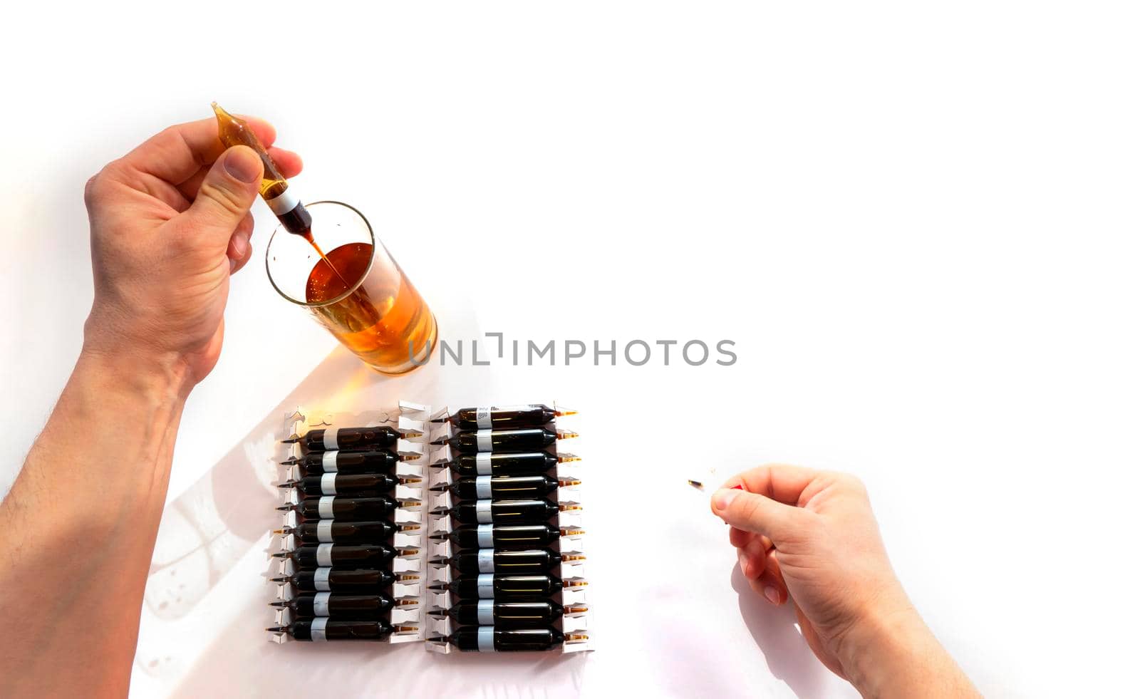 pour solution from an ampoule into a glass, dilute with water. horizontal perspective view of many brown ampoules set in pharmaceutical packaging white container