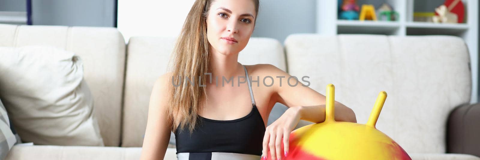 Portrait of attractive young woman pose with dumbbells and ball on floor. Girl prepare for active workout at home. Sport, physical activity, hobby concept