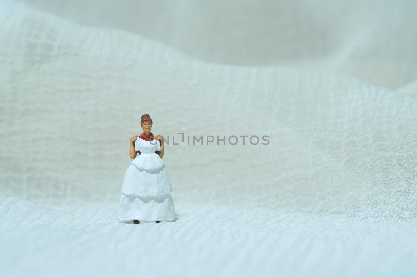 Women miniature people trying to choose wedding dress. Image photo