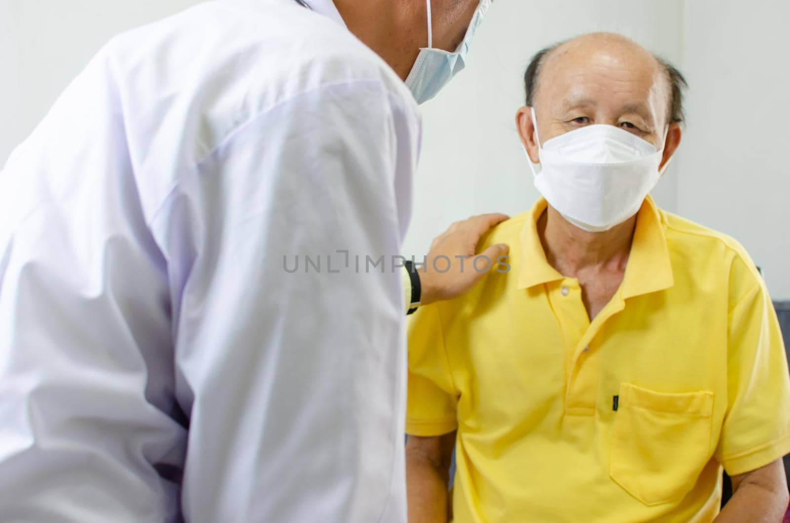 doctor held his shoulder and talked to an elderly man who was sick to give encouragement.